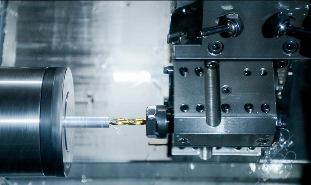 A CNC lathe drilling into a steel bar
